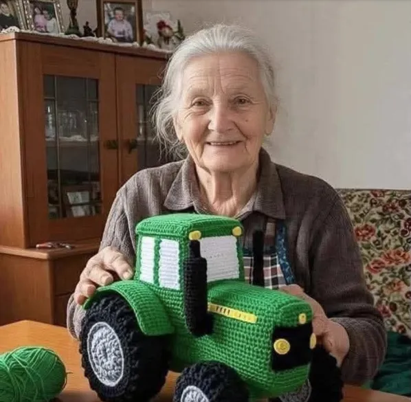 AI-generated image of an elderly woman holding a crocheted green toy tractor.